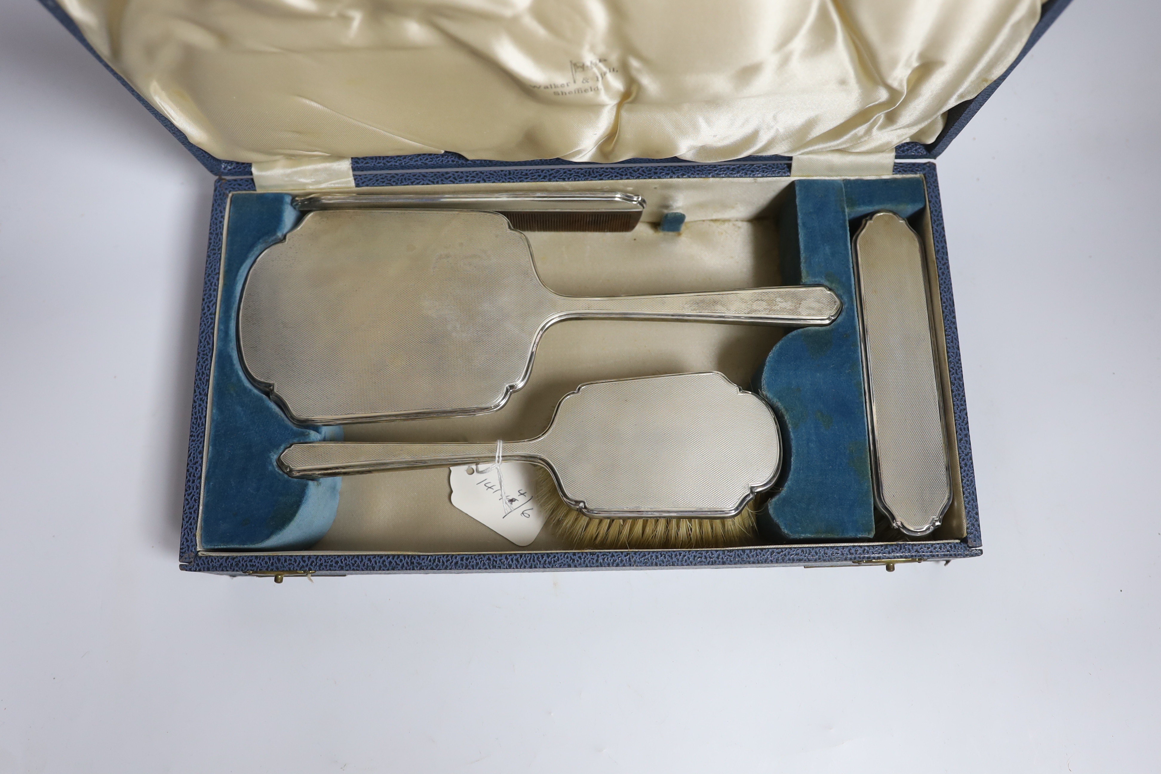 A cased George VI silver mounted four piece dressing table set, by Walker & Hall, Sheffield 1937.